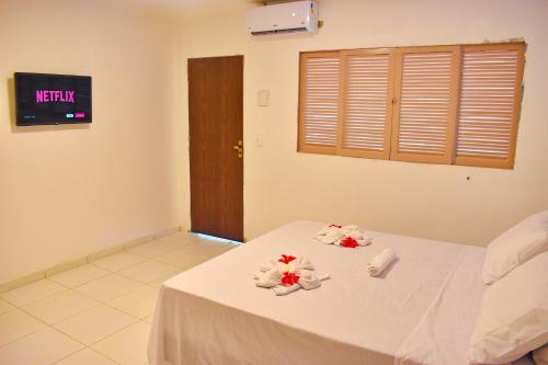a room with a white table with flowers on it at Caminho do Paraíso in Porto De Galinhas