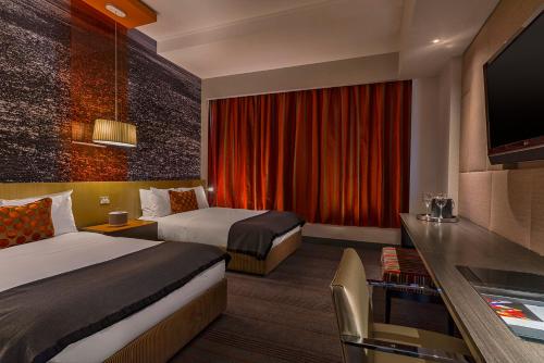 a hotel room with two beds and a flat screen tv at W Santiago in Santiago
