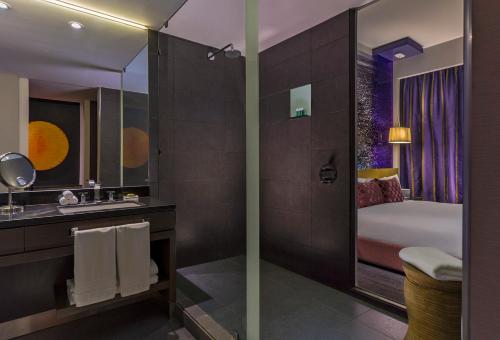 a bathroom with a shower and a sink and a mirror at W Santiago in Santiago