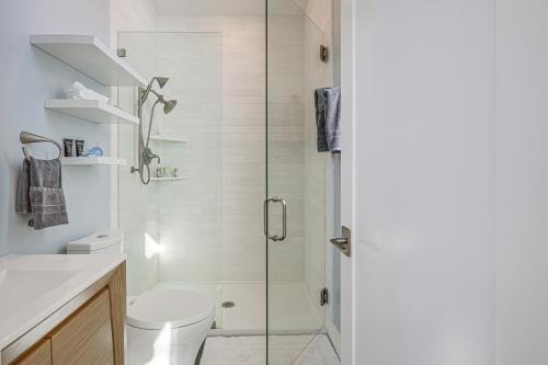 uma casa de banho com um WC e uma cabina de duche em vidro. em Little House By the Sea Steps to Surfers Beach! em El Granada