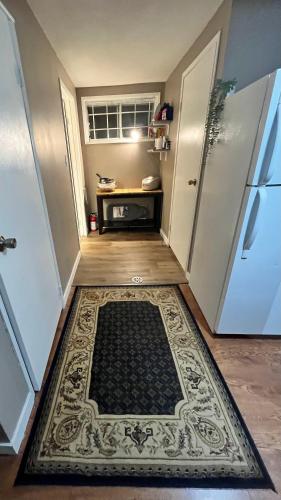 a hallway with a rug on the floor next to a refrigerator at West Edmonton Perle Palace in Edmonton