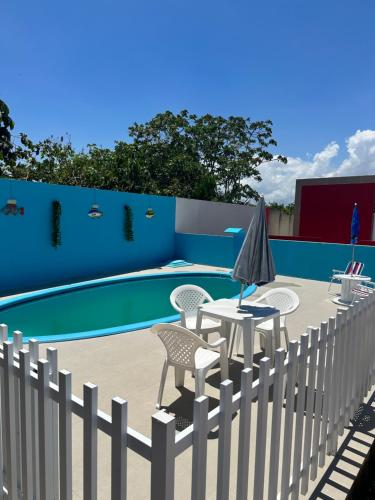 een hek met een tafel en stoelen naast een zwembad bij Vivendas Piscina e Mar in Aracaju