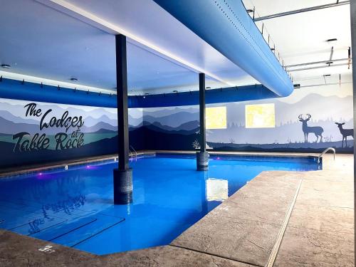 einen Pool in einem Gebäude mit Wandgemälde in der Unterkunft Rock and Timber Lodge in Branson