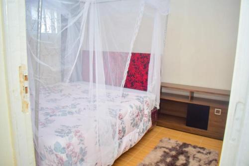1 dormitorio con 1 cama con dosel en Trinity Garden en Nairobi