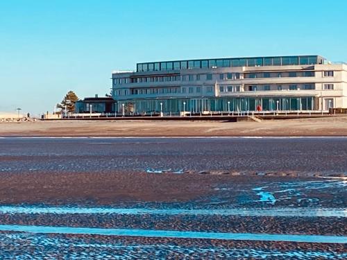 a large building on the side of a beach at Eden Stay in Morecambe