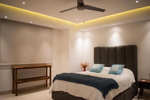 a bedroom with a large bed with a ceiling fan at MarAzul Beachfront Gem in Bucerías