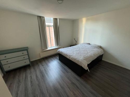 een slaapkamer met een bed en een dressoir bij City Appartement with Private free parking in Enschede