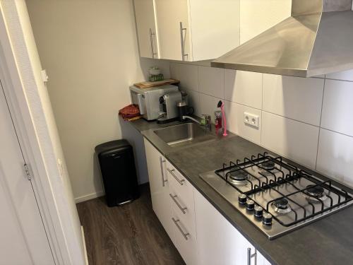 a small kitchen with a stove and a sink at 88 11City Appartement with Private free parking in Enschede