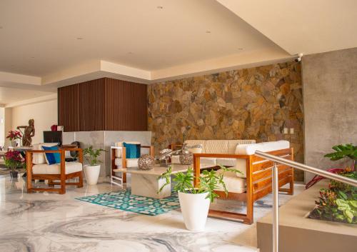 a lobby with furniture and a stone wall at MarAzul Beachfront Gem in Bucerías