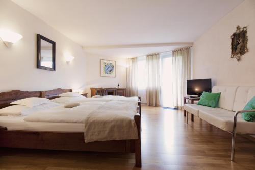 a bedroom with two beds and a couch and a television at Romantik Hotel Alte Vogtei in Hamm