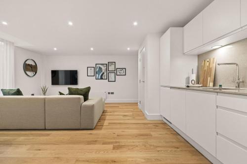 sala de estar blanca con sofá y cocina en Atlas House Five, en Harrogate