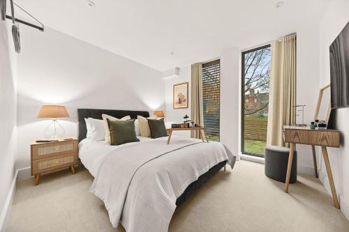 a white bedroom with a bed and a window at Atlas House Five in Harrogate