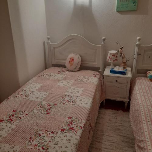 a bedroom with a bed with a pink and white quilt at Monte das Rolas - A Serenidade mora Aqui! in Ferraria