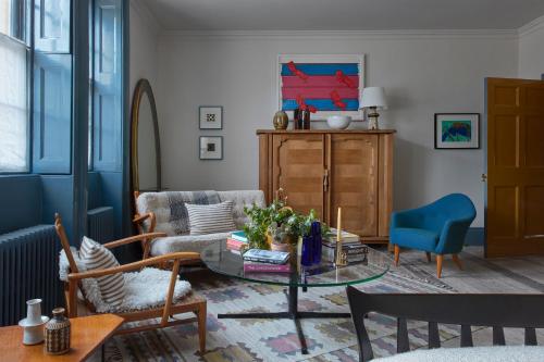 sala de estar con mesa y sofá en Suites @ The Townhouse by designer Tobias Vernon en Bath