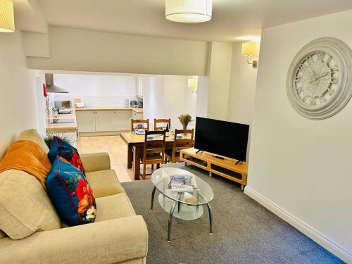 a living room with a couch and a table at Cowpasture Apt - Ilkley Central in Ilkley