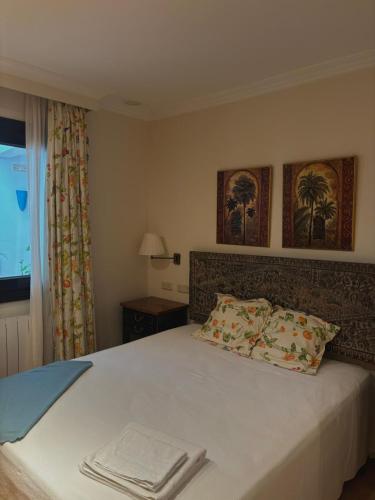 1 dormitorio con 1 cama con 2 almohadas y ventana en GAV Mondragón en Ronda