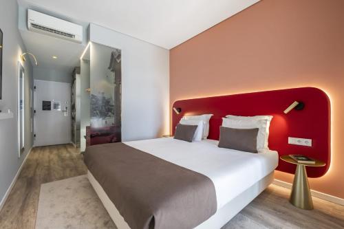 a bedroom with a large bed with a red headboard at King David Suites by Homie in Funchal