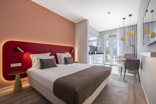una camera con un grande letto con testiera rossa di King David Suites by Madeira Sun Travel a Funchal
