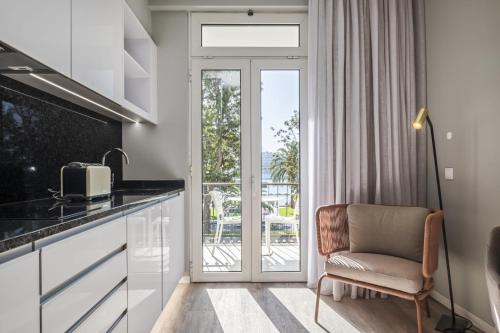 a kitchen with a chair next to a sliding glass door at King David Suites by Homie in Funchal