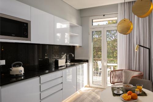 a kitchen with white cabinets and a table with oranges on it at King David Suites by Homie in Funchal
