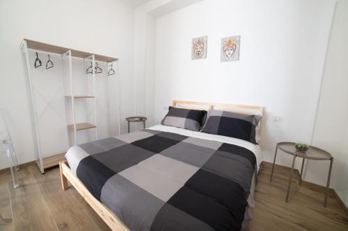 1 dormitorio con 1 cama en blanco y negro y 2 mesas en Residence Le Tre Piazze, en Siracusa