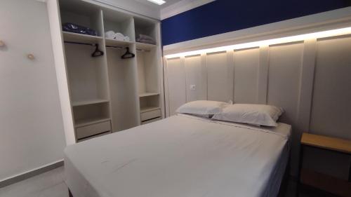 a bedroom with a white bed and a blue wall at Family House - Curitiba in Curitiba