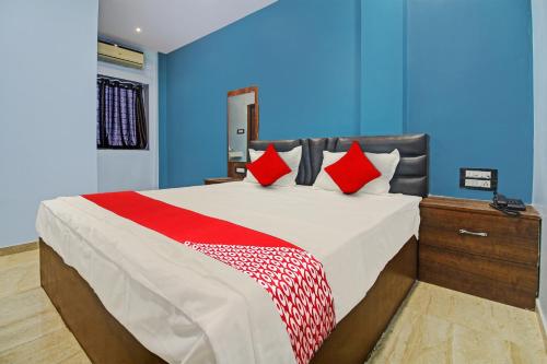 1 dormitorio con 1 cama grande con almohadas rojas en OYO Flagship Rr Lodging And Boarding, en Itwāri