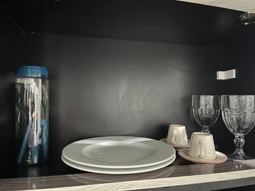 a plate and two wine glasses on a counter at •Incrível suíte com: acesso totalmente individual! in João Pessoa