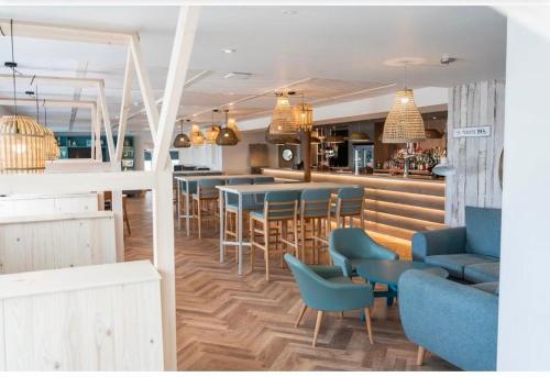 a restaurant with blue chairs and a bar at Newland's in Rochester