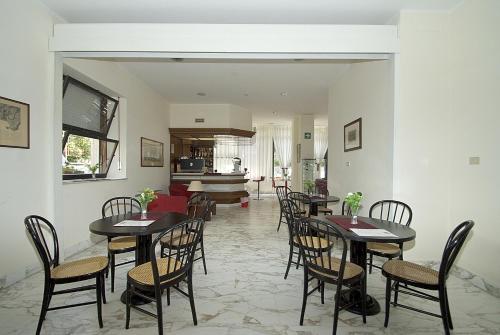 un comedor con mesas, sillas y un piano en Hotel Mediterraneo, en Chianciano Terme