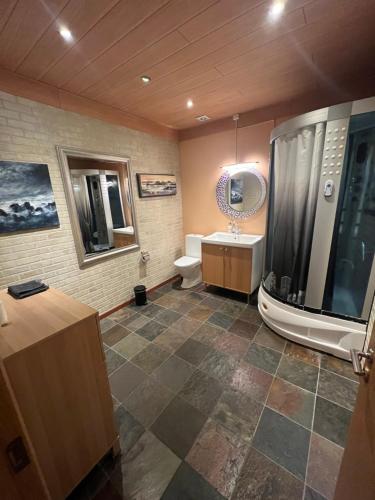 La salle de bains est pourvue de toilettes, d'un lavabo et d'une baignoire. dans l'établissement Art Hostel and Apartments, à Stokkseyri