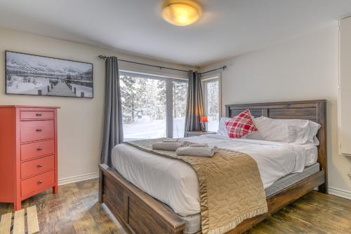 Un dormitorio con una cama grande y una ventana en 46 Impasse - Lac Superior Getaway 3BR Home w Hot Tub en Mont-Tremblant