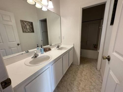 ein Badezimmer mit zwei Waschbecken und einem großen Spiegel in der Unterkunft Sunset themed retreat- Sleeps 10 in Davenport