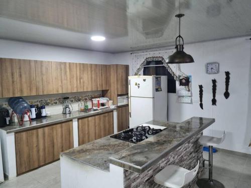 uma cozinha com um fogão e um frigorífico branco em Cómoda casa de campo em Ibagué