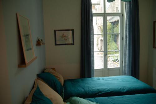 a room with a window and a bed in front of it at Le charmant cocon in La Bourboule