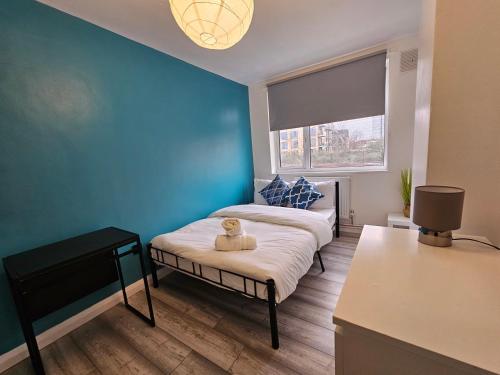 een slaapkamer met een bed met een teddybeer erop bij London Mile End Rooms in Londen