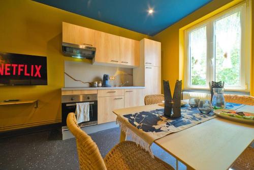 une cuisine avec une table avec des chaises et une salle à manger dans l'établissement JapanRoom Jacuzzi&Sauna Haut de gamme parking free, à Mulhouse