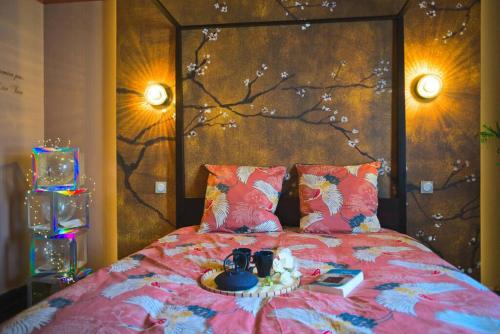 - un lit avec une couette rose et une table dans l'établissement JapanRoom Jacuzzi&Sauna Haut de gamme parking free, à Mulhouse