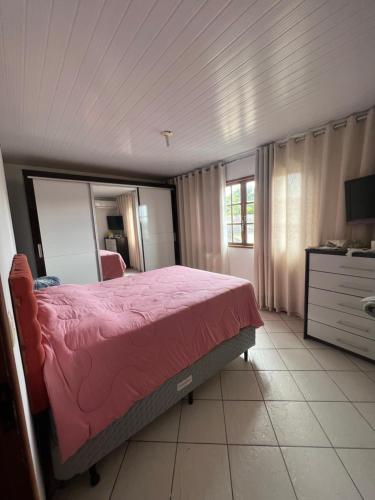 1 dormitorio con cama rosa y espejo en Portal_105 en Juiz de Fora