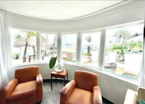 two chairs in a room with large windows at Walkabout 1 Tower Suite in the heart of Hollywood Beach in Hollywood