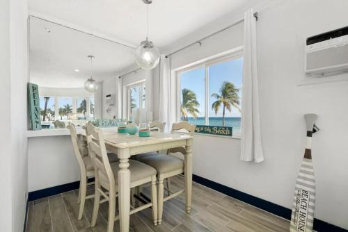 a dining room with a table and chairs and the ocean at Walkabout 1 Tower Suite in the heart of Hollywood Beach in Hollywood