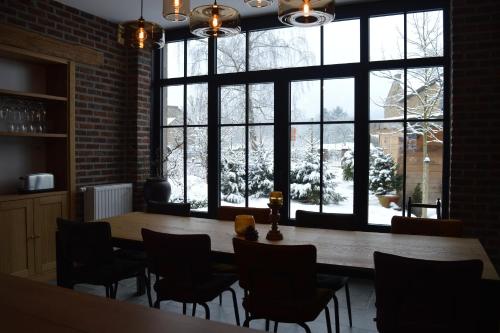 a room with a table and chairs and a large window at La Jardinière in Érezée