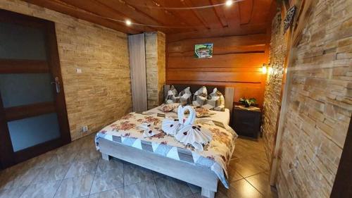 - une chambre avec un lit et un mur en bois dans l'établissement Apartmán u Žanety, à Ždiar