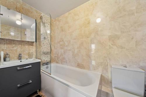y baño con bañera y lavamanos. en Cozy Apartment in Greater London – 1BR,1 Bath, en Londres