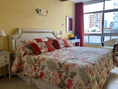 a bedroom with a large bed with red pillows at ubicacion perfecta en punta in Punta del Este