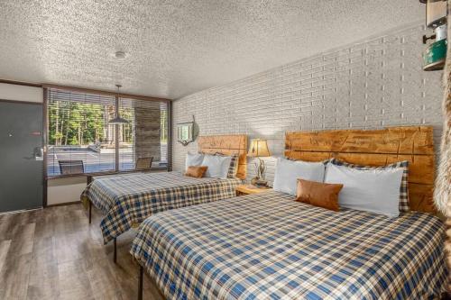 een hotelkamer met 2 bedden en een raam bij Stonegate Lodge Sleeps 4 Fast WiFi Firepits TV Salt Water Pool Room #204 in Eureka Springs