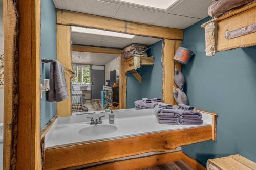 een badkamer met een wastafel en een spiegel bij Stonegate Lodge Sleeps 4 Fast WiFi Firepits TV Salt Water Pool Room #204 in Eureka Springs