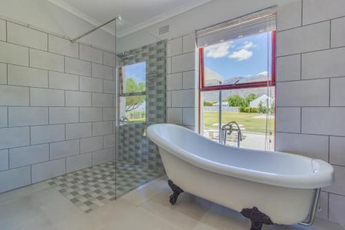 una bañera en un baño con ventana en Mountville House, en Porterville