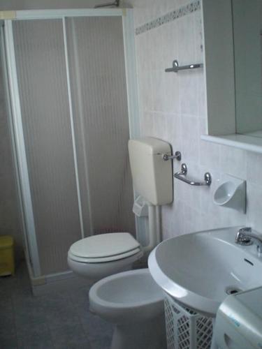 a white bathroom with a toilet and a sink at Centralissimo Mi.Ma in Milano Marittima