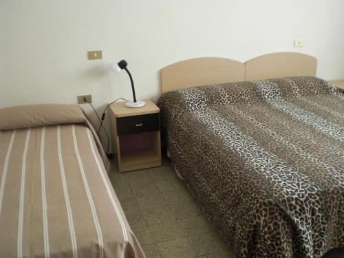 a bedroom with a bed and a lamp on a night stand at Centralissimo Mi.Ma in Milano Marittima